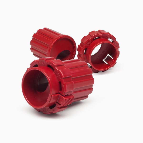 Red plastic component used for cinching a rope, designed and produced by Xcentric